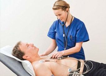 Una enfermera está examinando el corazón de un hombre con un estetoscopio.