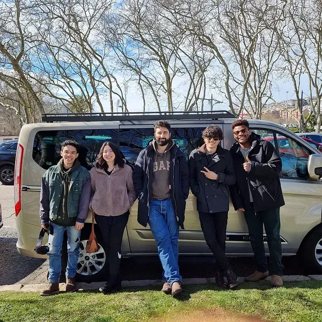Un grupo de personas paradas frente a una camioneta que dice