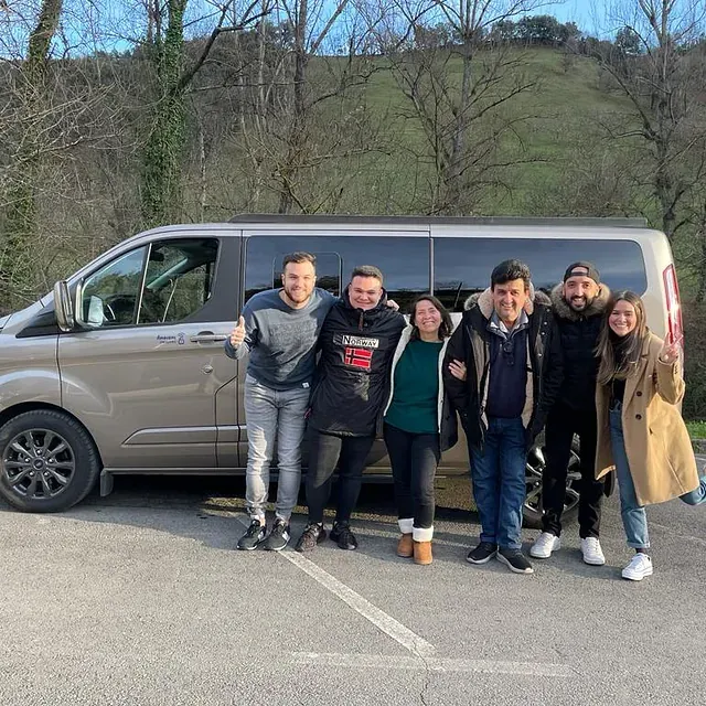 Un grupo de personas posa para una fotografía delante de una camioneta.