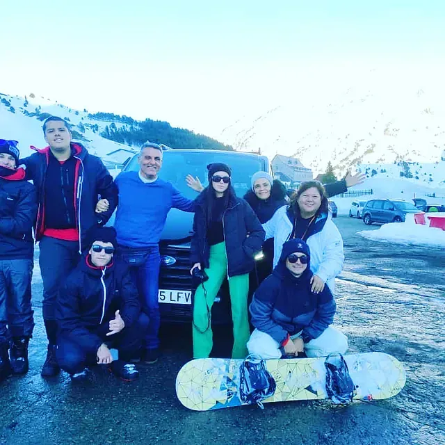 Un grupo de personas posando frente a un coche con una matrícula que dice 5lfv