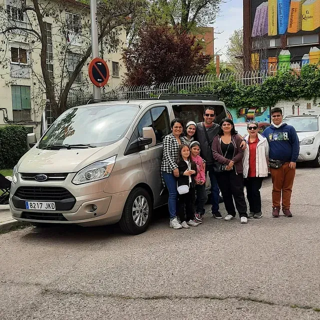Un grupo de personas posa para una fotografía delante de una camioneta.