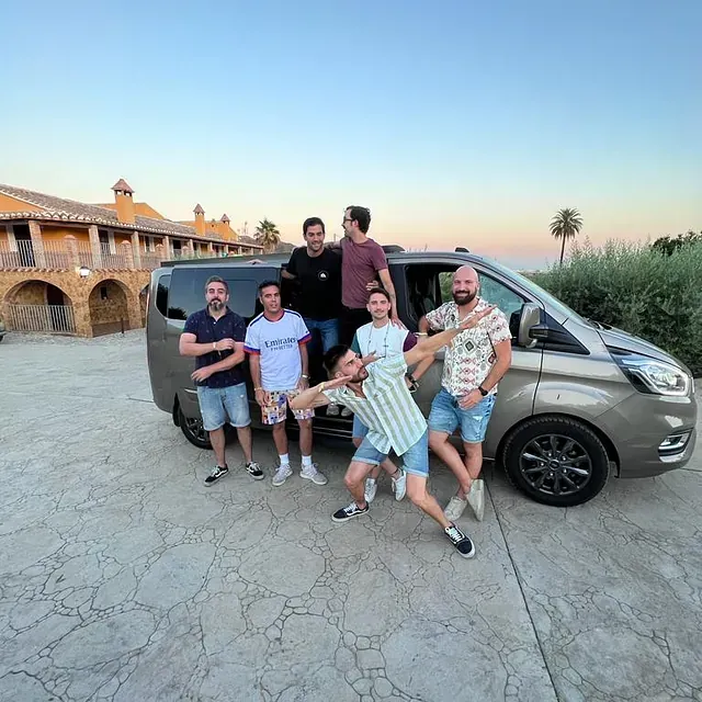 Un grupo de hombres posa para una fotografía frente a una camioneta.