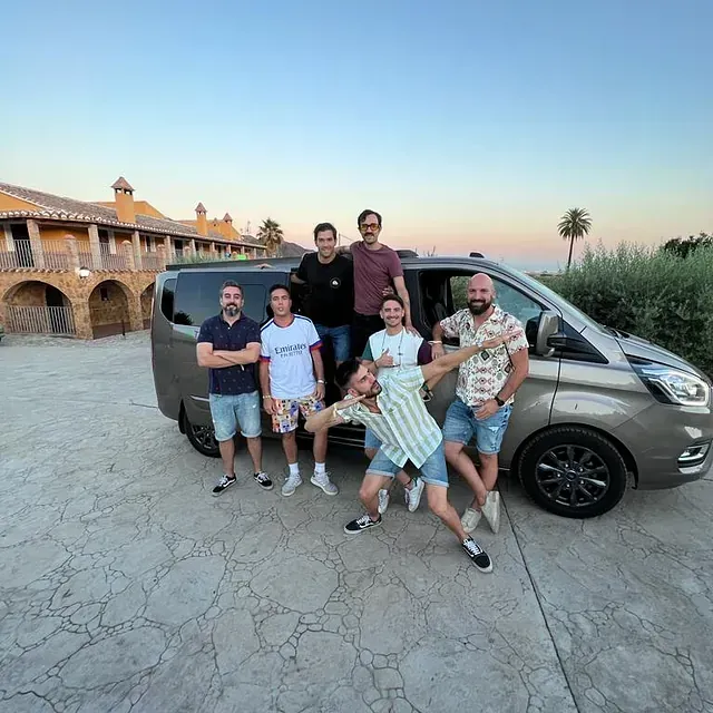 Un grupo de hombres posa para una fotografía frente a una camioneta.