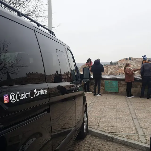 Una furgoneta negra con una pegatina en el lateral que dice aventura personalizada