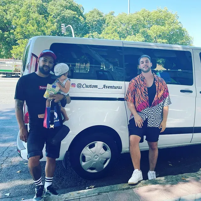 Dos hombres parados frente a una camioneta blanca que dice Custom Aventuras