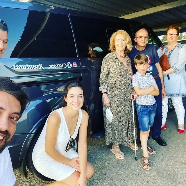 Un grupo de personas posando para una foto frente a una camioneta que dice motul