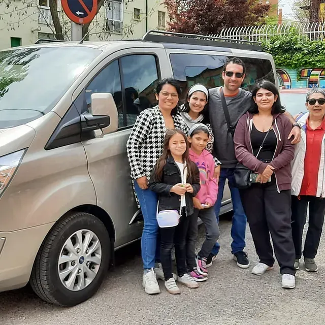 Un grupo de personas posando para una foto frente a una camioneta.
