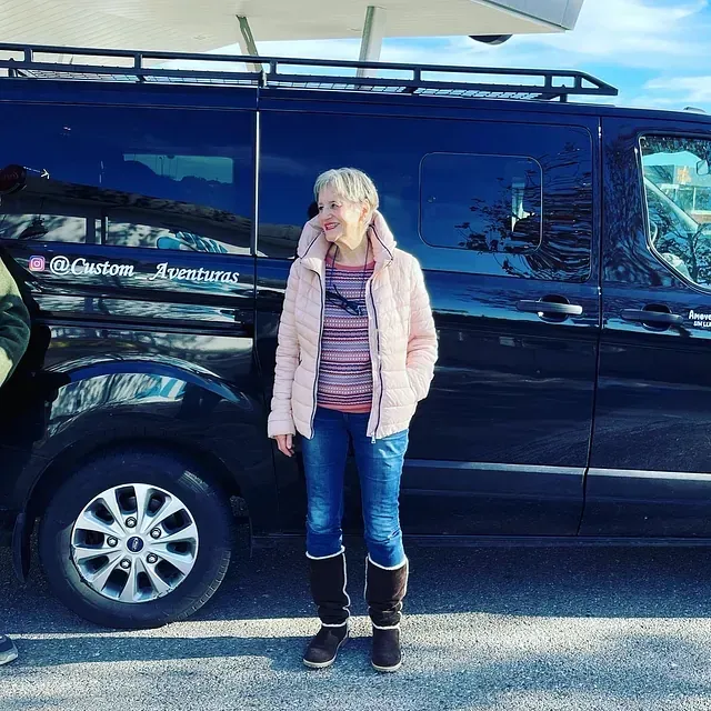 Una mujer está parada frente a una camioneta que dice