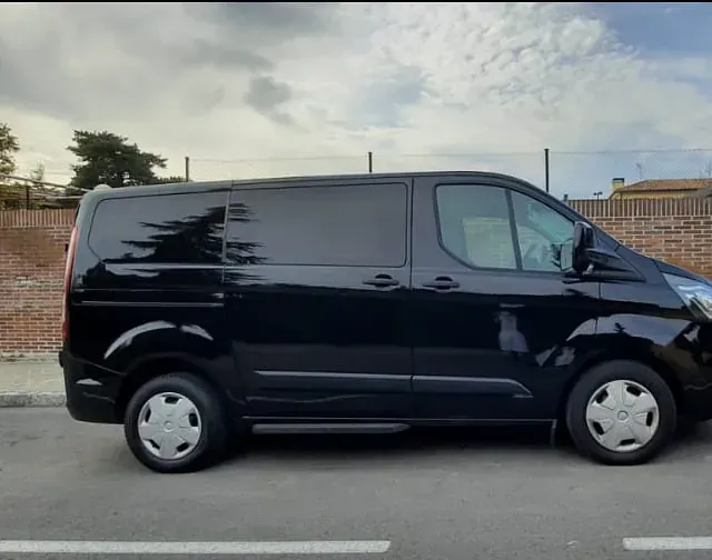 Una camioneta negra está estacionada al costado de la carretera