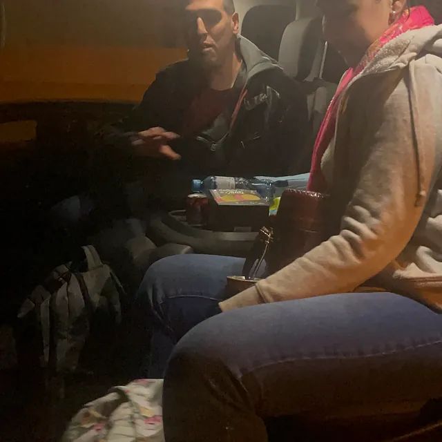 Un hombre y una mujer están sentados en el asiento trasero de un coche.