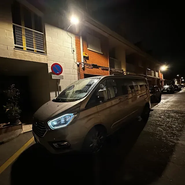Una camioneta está estacionada al costado de una calle por la noche.