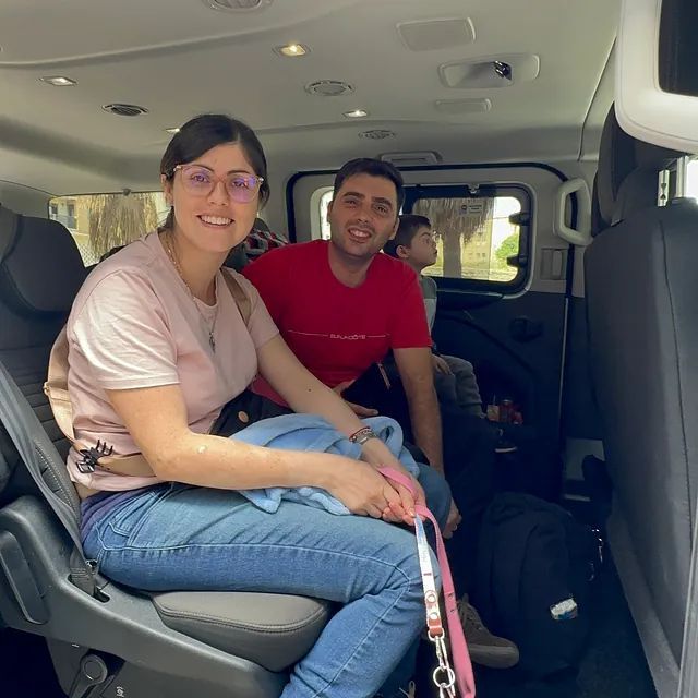 Un hombre y una mujer están sentados en la parte trasera de una camioneta.