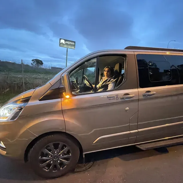 Una mujer está sentada en el asiento del conductor de una camioneta.