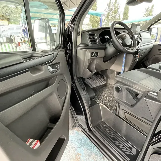 El interior de un coche con la puerta abierta y un volante.