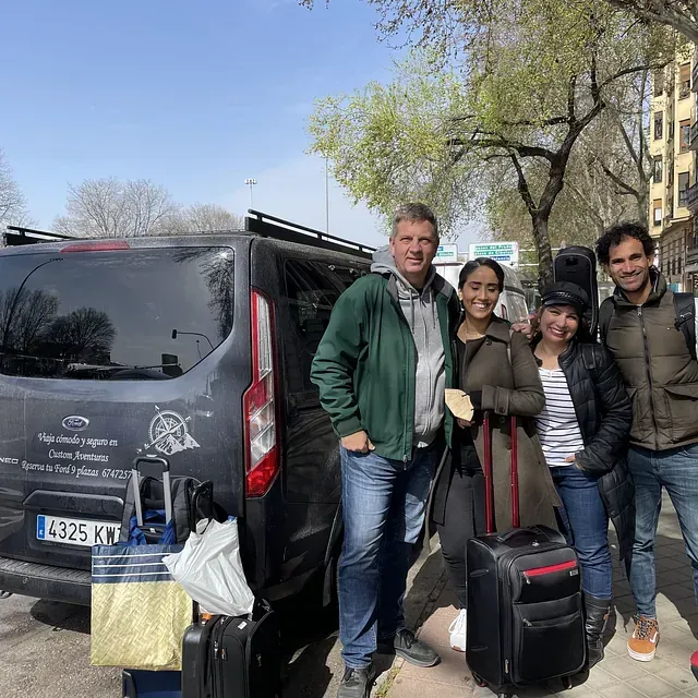 Un grupo de personas posa para una fotografía delante de una camioneta.