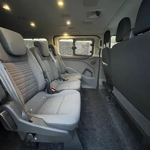 El interior de una furgoneta con muchos asientos y una ventana.
