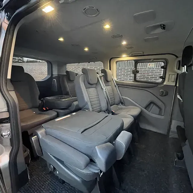 El interior de una camioneta negra con la puerta abierta y un volante.