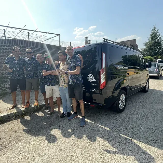 Un grupo de hombres posa para una fotografía frente a una camioneta.