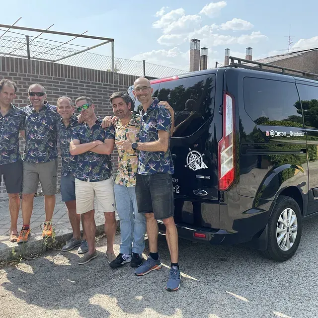 Un grupo de hombres posa para una fotografía frente a una camioneta.