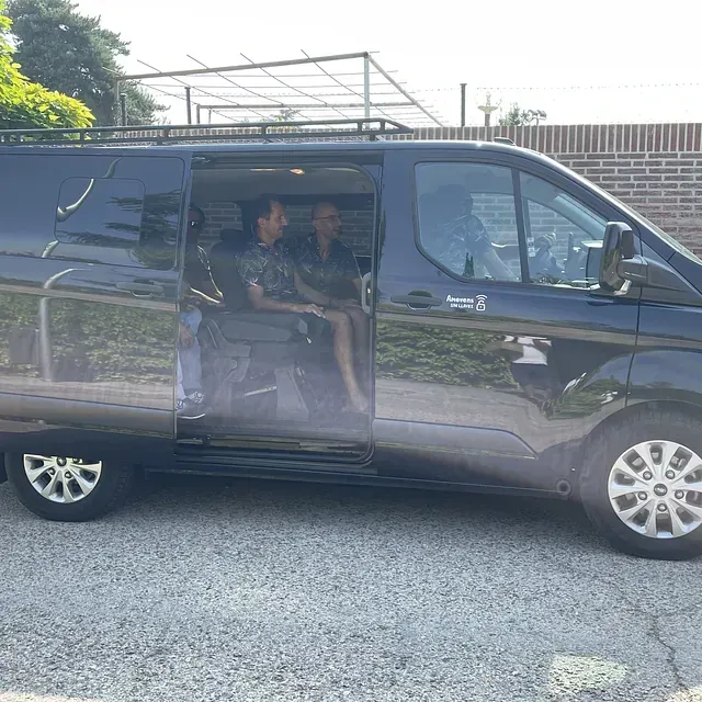 Dos personas están sentadas en una camioneta con la puerta abierta.