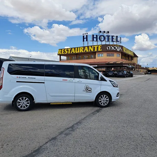 Una camioneta blanca está estacionada frente al restaurante de un hotel.