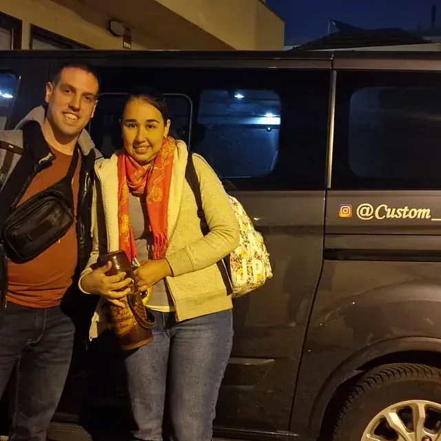 Un hombre y una mujer de pie frente a una camioneta que dice