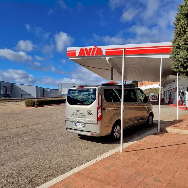 Una furgoneta está aparcada bajo un toldo que dice avia