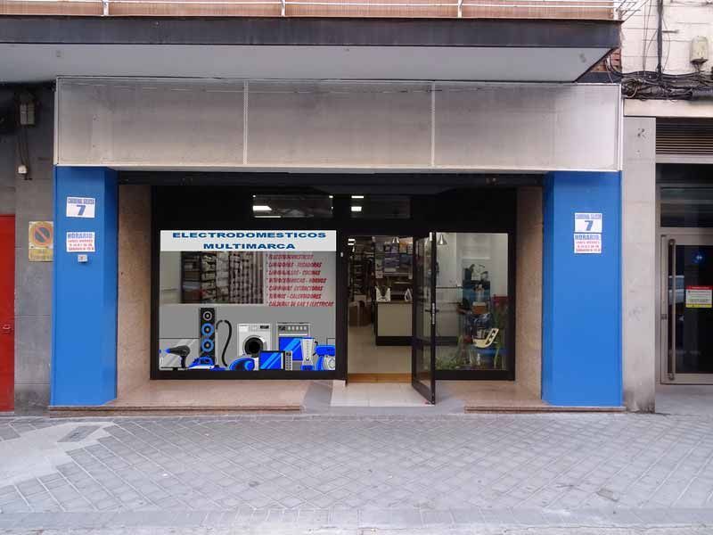 Escaparate con marco azul y puerta abierta, mostrando aparatos electrónicos en su interior. Número 7 en columnas. Acera.