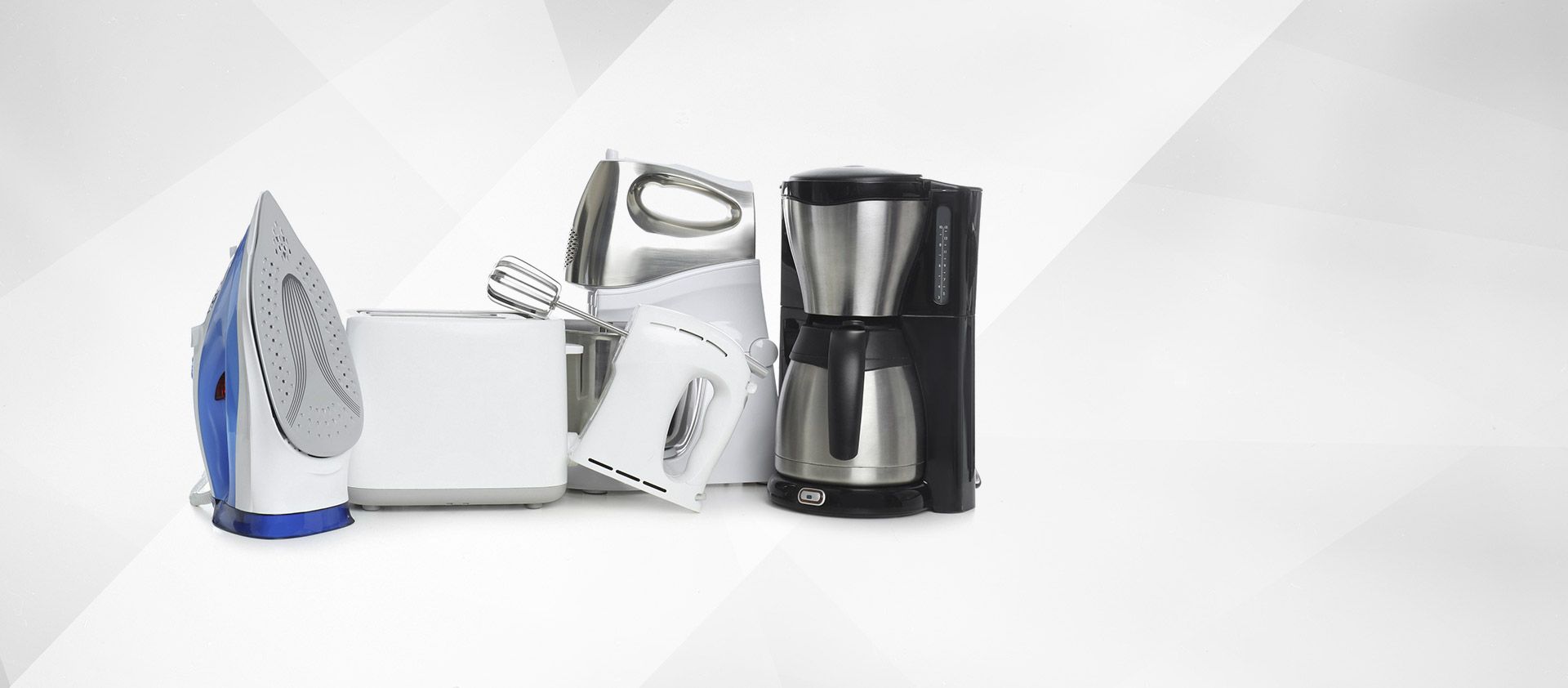 Electrodomésticos de cocina variados, que incluyen una plancha, una tostadora, batidoras de mano y una cafetera, dispuestos sobre una superficie blanca.