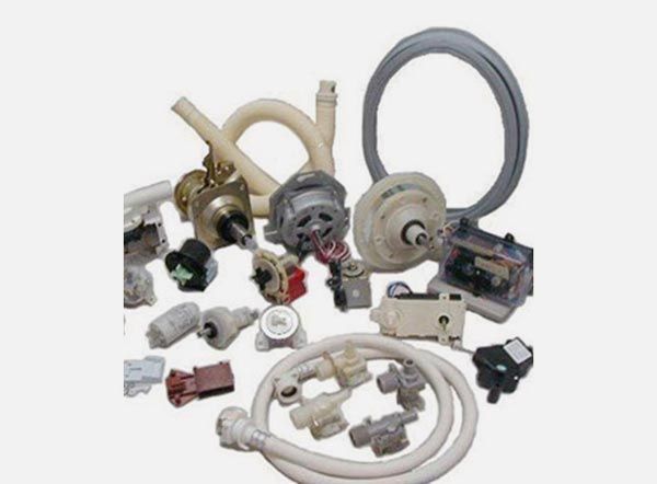 Las piezas de la lavadora, incluidas mangueras, motores, válvulas y módulos de control, están dispuestas sobre un fondo blanco.