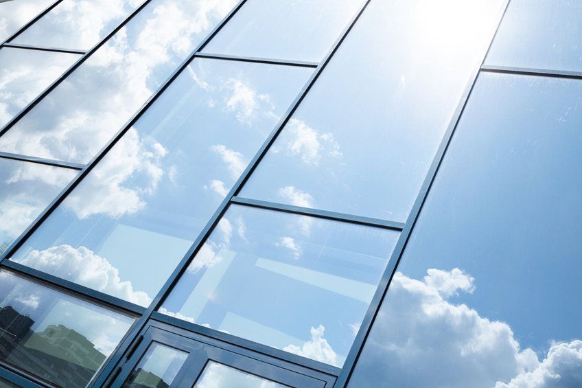 El cielo se refleja en las ventanas de un edificio.