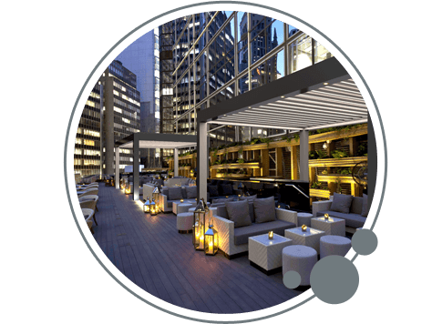 Una imagen de un área de patio con una pérgola y muchos muebles.