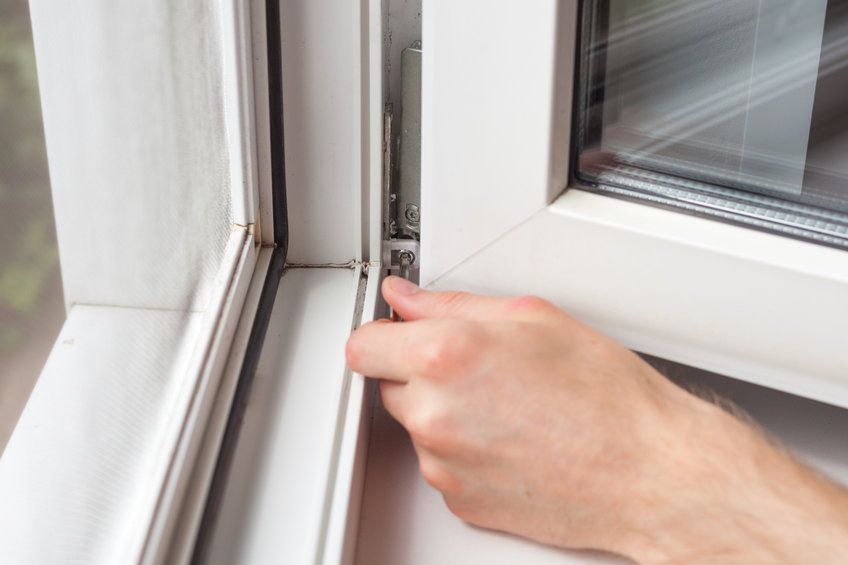 Una persona está arreglando una ventana con un destornillador.