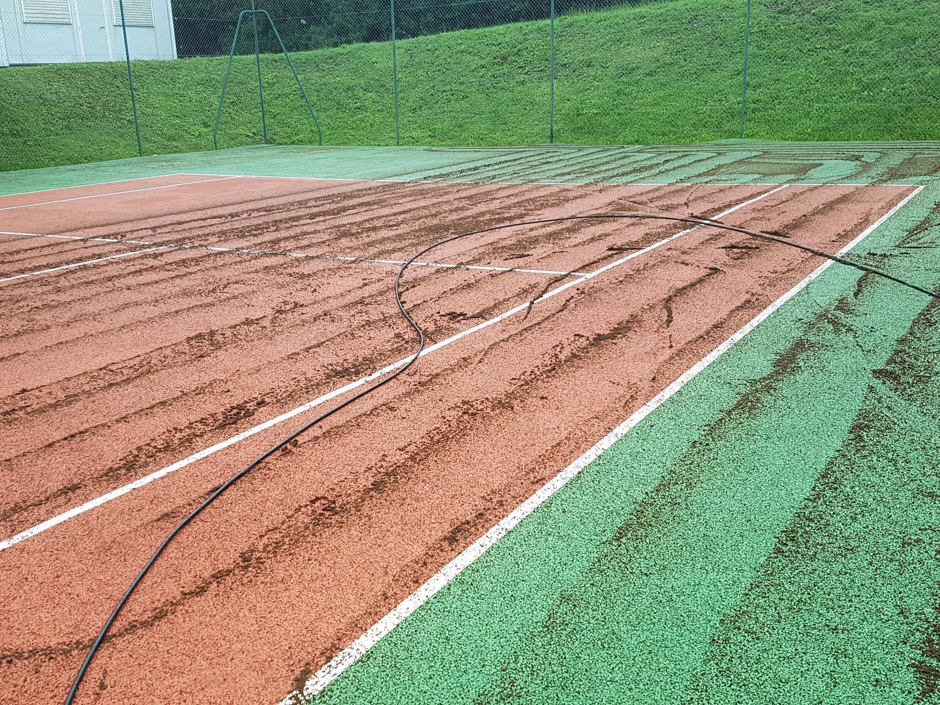 Terrain de baseball avec un champ intérieur en terre battue rouge et un champ extérieur en gazon synthétique vert.