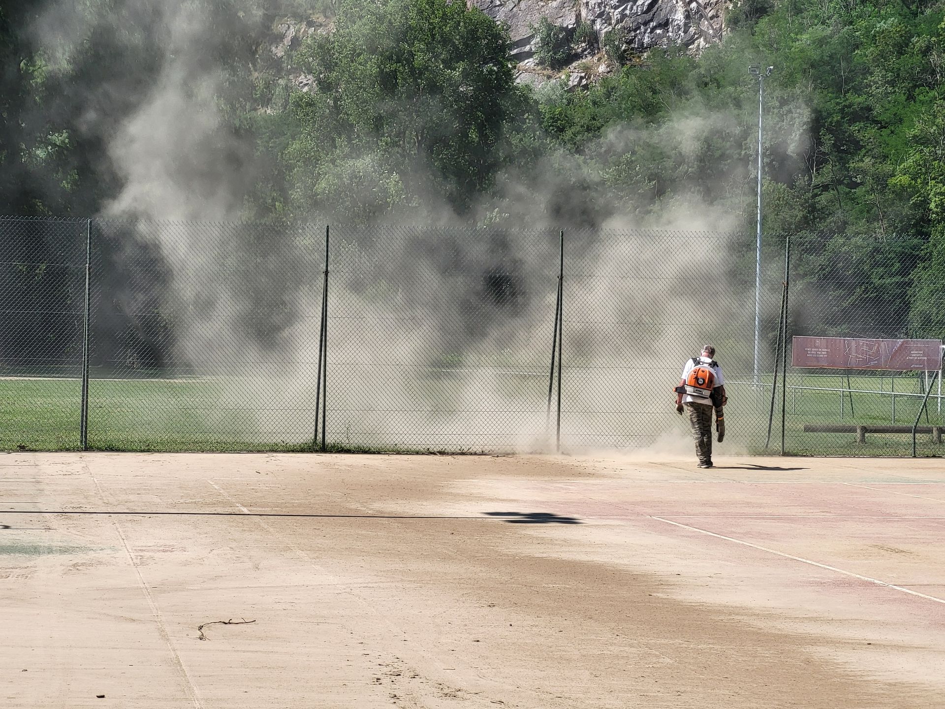 Nettoyage suite à l'inondation d'un court de tennis.