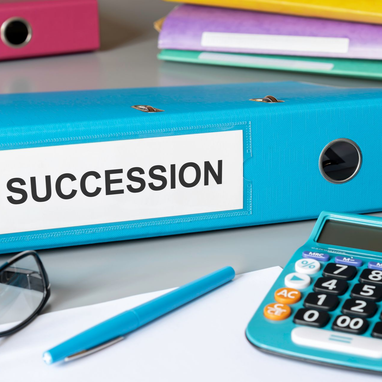 Classeur bleu étiqueté devant une calculatrice, un stylo et des feuilles de papier.