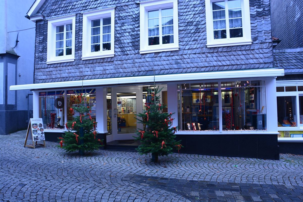 Ein Backsteingebäude mit Weihnachtsbäumen davor