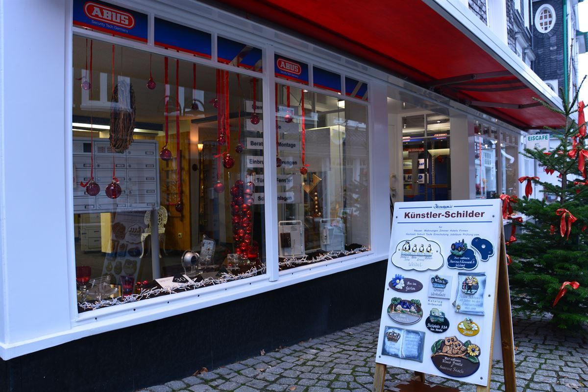 Eine Ladenfront mit einem Schild davor und einem Weihnachtsbaum im Hintergrund.