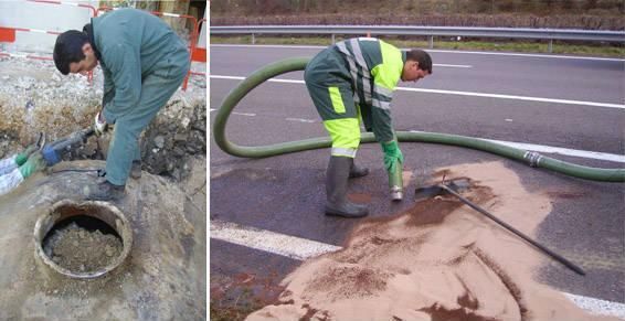 Deux ouvriers nettoient une bouche d'égout et des débris de chaussée à l'aide d'une pelle et d'un tuyau d'aspirateur.