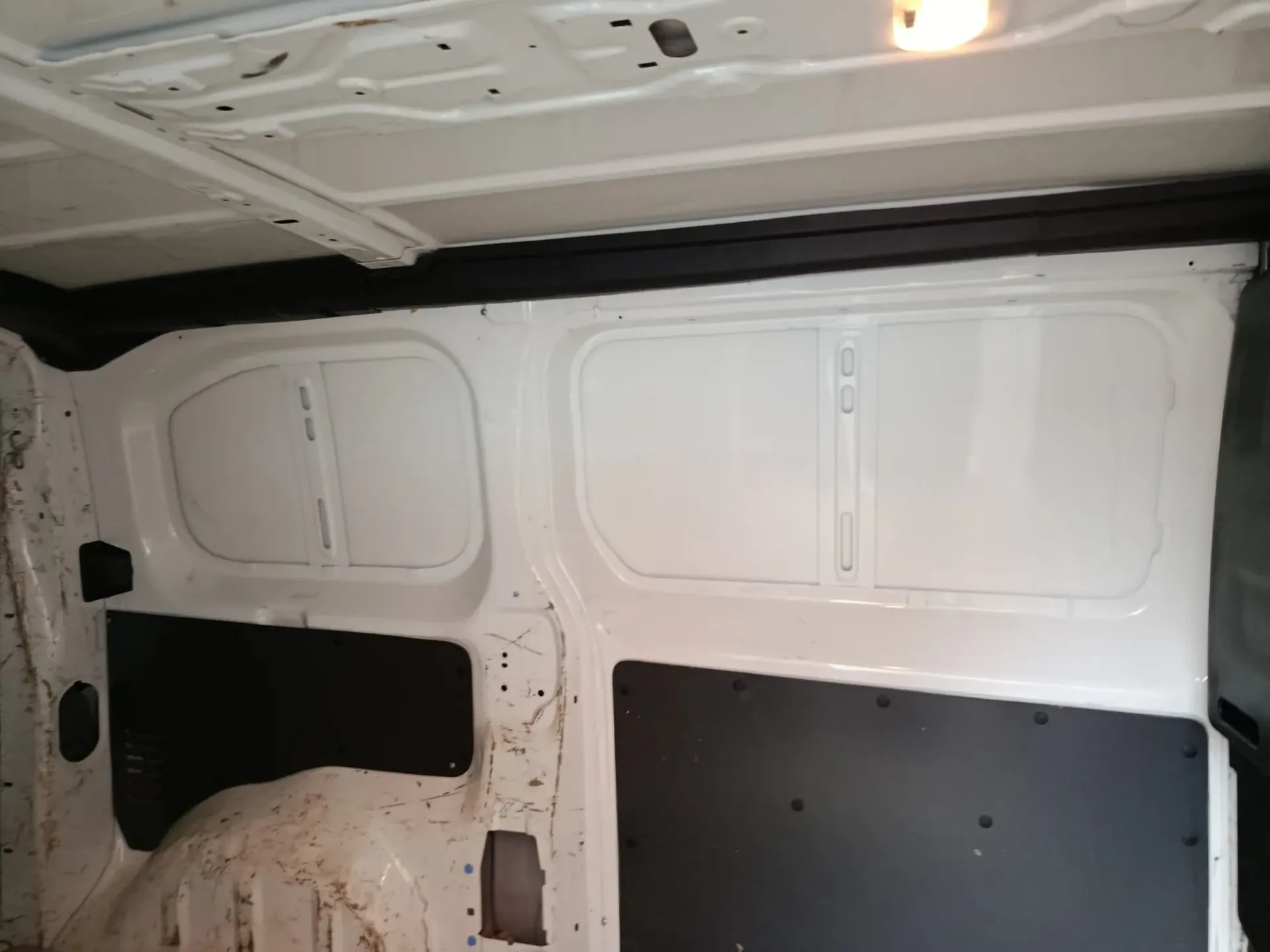 Vista interior de una furgoneta blanca con paneles de pared aislados.