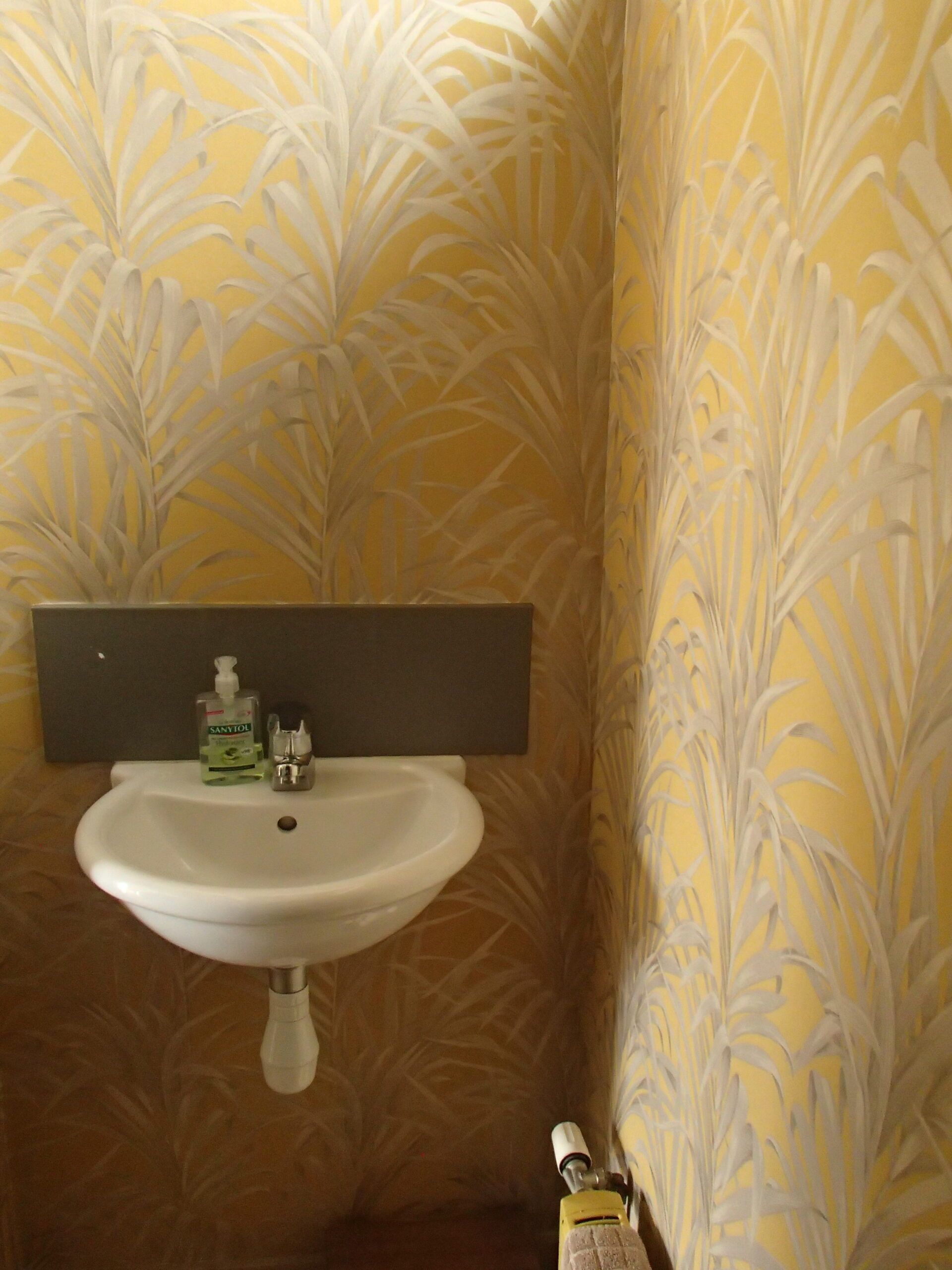 Salle de bain avec papier peint jaune à motif végétal