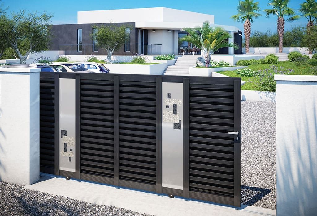 Portail moderne en métal noir avec panneaux argentés devant une maison blanche avec aménagement paysager.