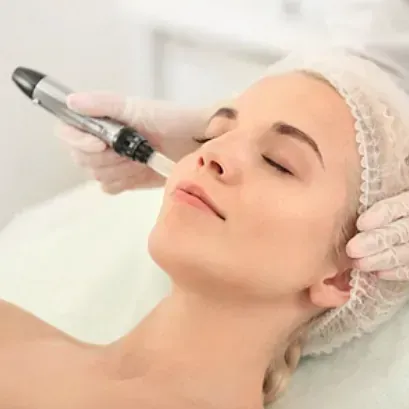 Una mujer está recibiendo un tratamiento facial con un bolígrafo en la cara.