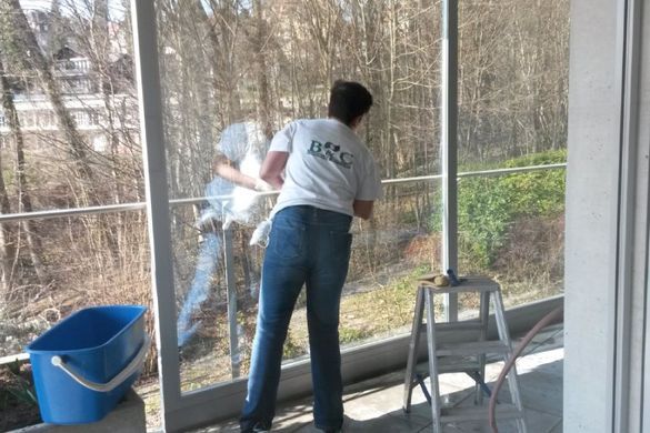 Putzfrau von der B&C Cleaning Services GmbH putzt ein Fenster