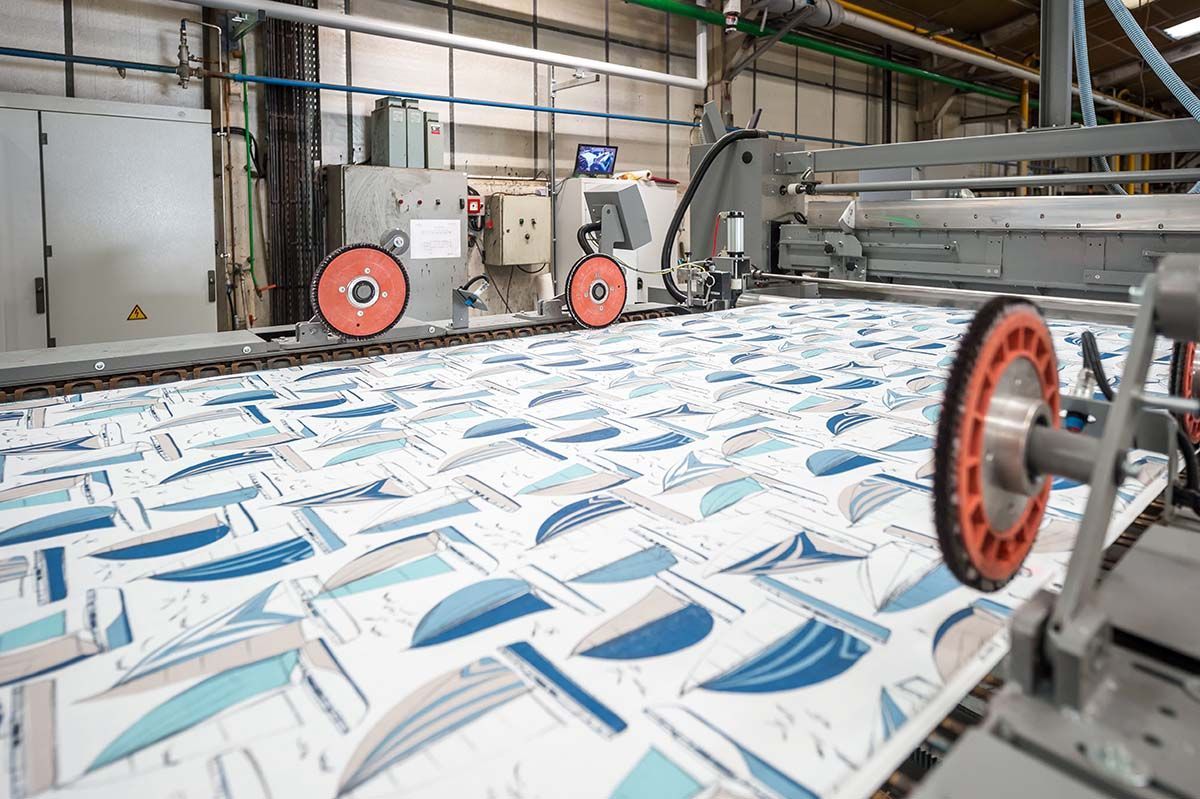 Machine d'impression textile avec un motif de voilier bleu et blanc.