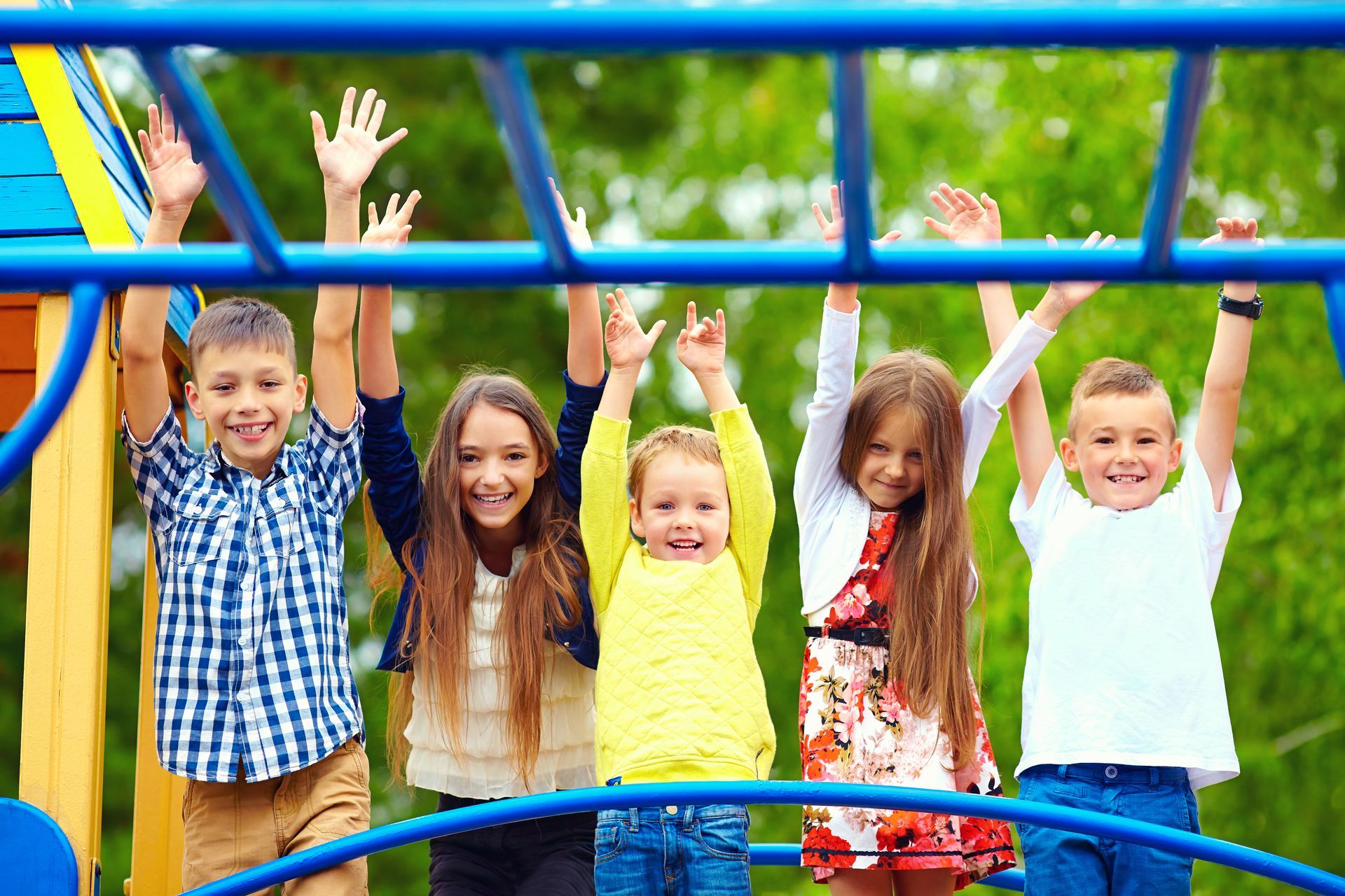 Eine Gruppe Kinder spielt auf einem Klettergerüst auf einem Spielplatz.