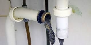 Un primer plano de un tubo de drenaje con agua saliendo de él.