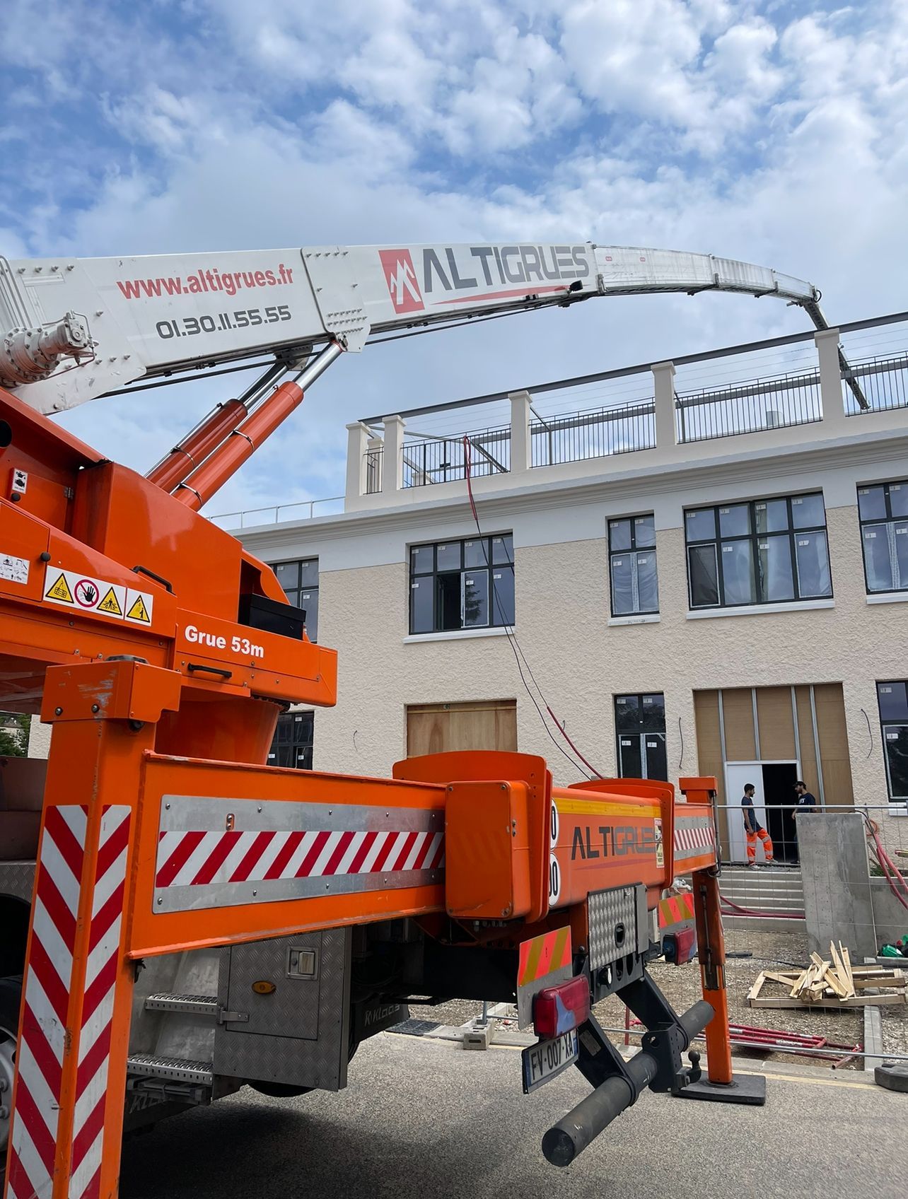 Engin orange avec bras pour travaux de levage