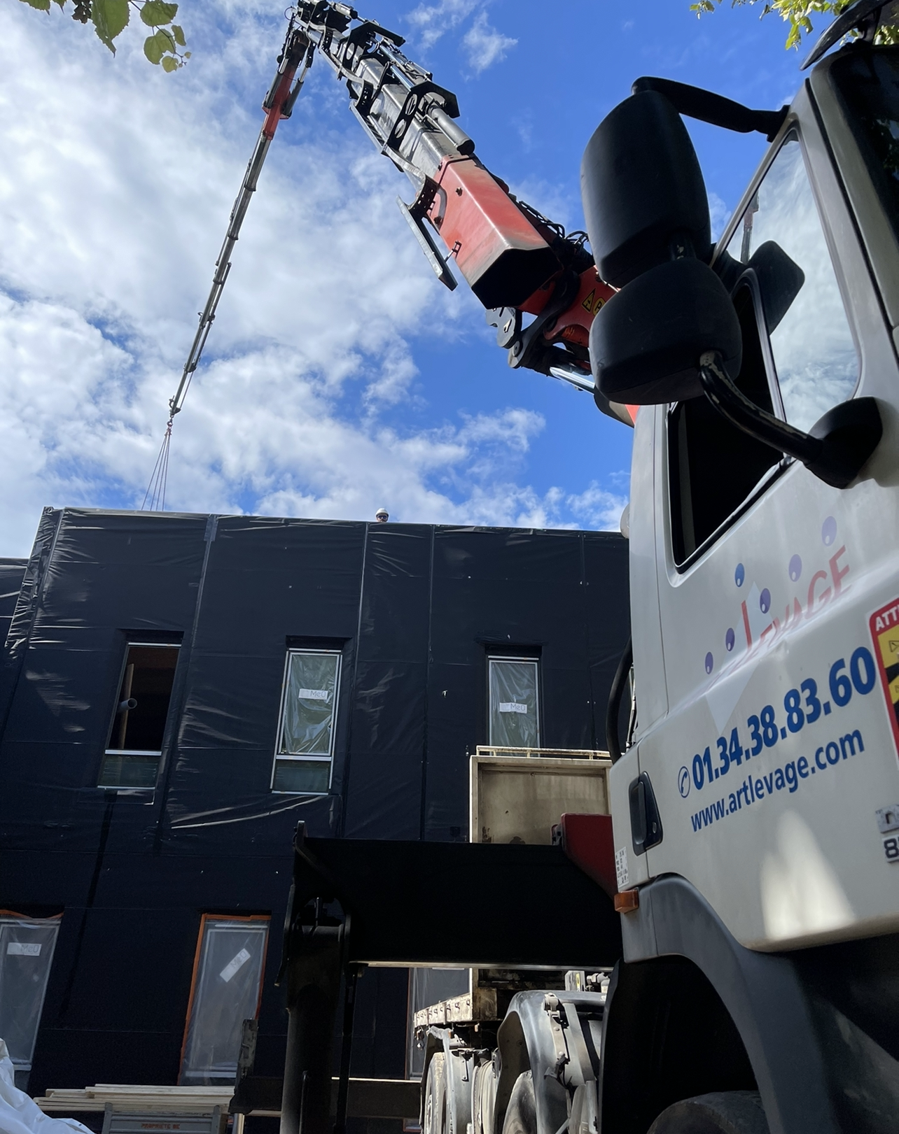 Camion blanc avec grue rouge pour travaux de levage
