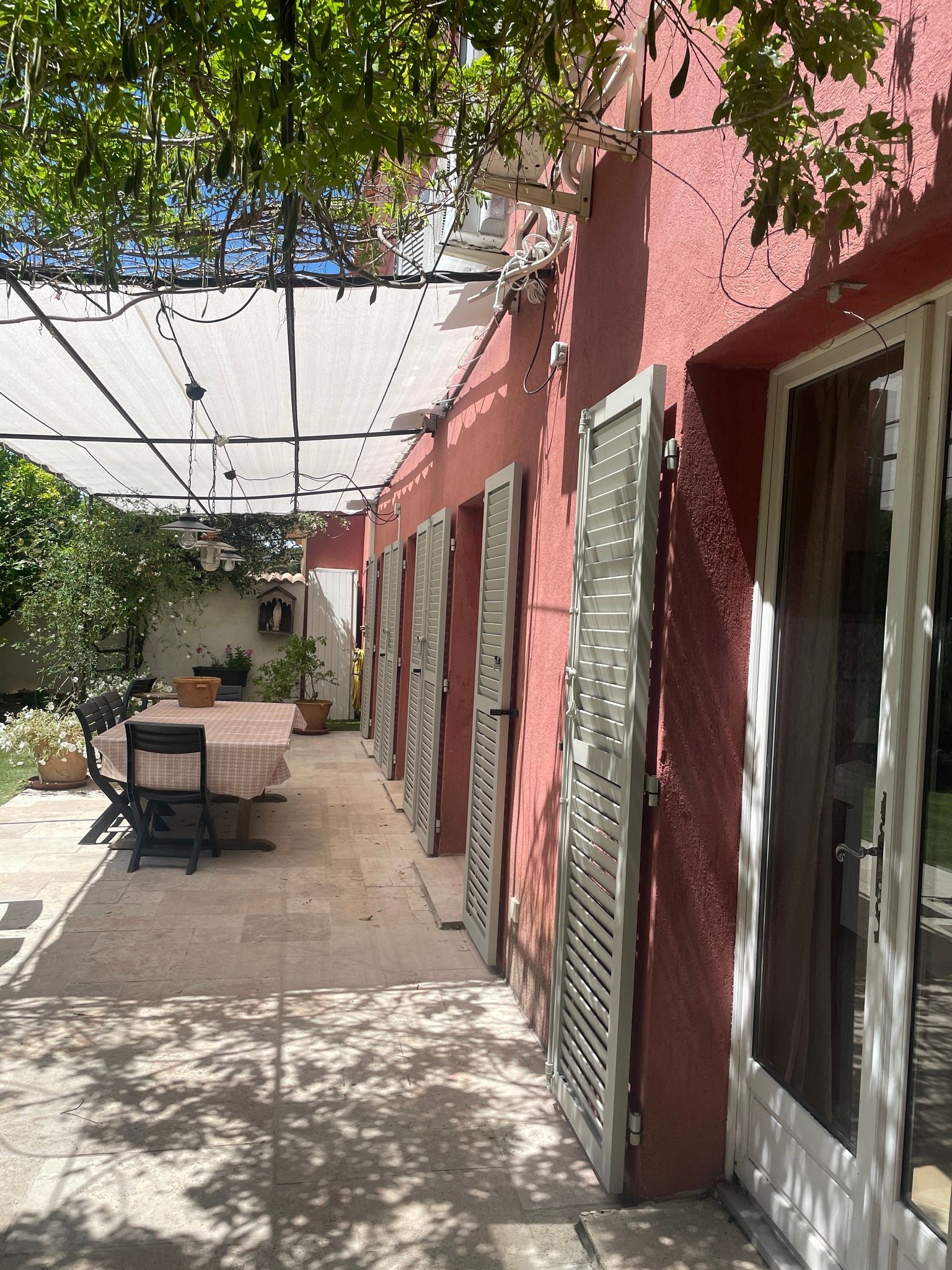 Terrasse d'une villa rouge et focus sur pergola